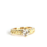 Bague solitaire Joséphine en or 18 carats avec diamant rond serti grain et anneau texturé à motif végétal.