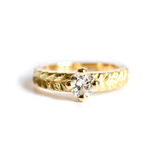 Bague solitaire Joséphine en or 18 carats avec diamant rond serti grain et anneau texturé à motif végétal.